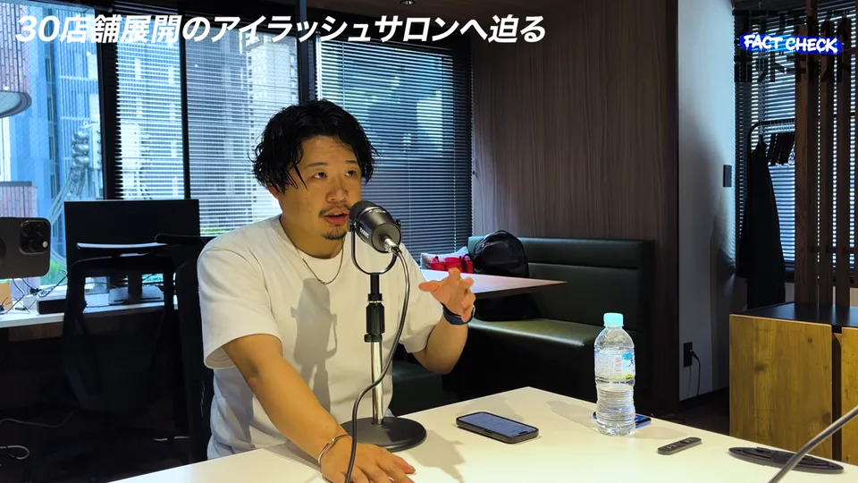 直営とフランチャイズの店舗数の内訳を手振りで説明する臼井社長